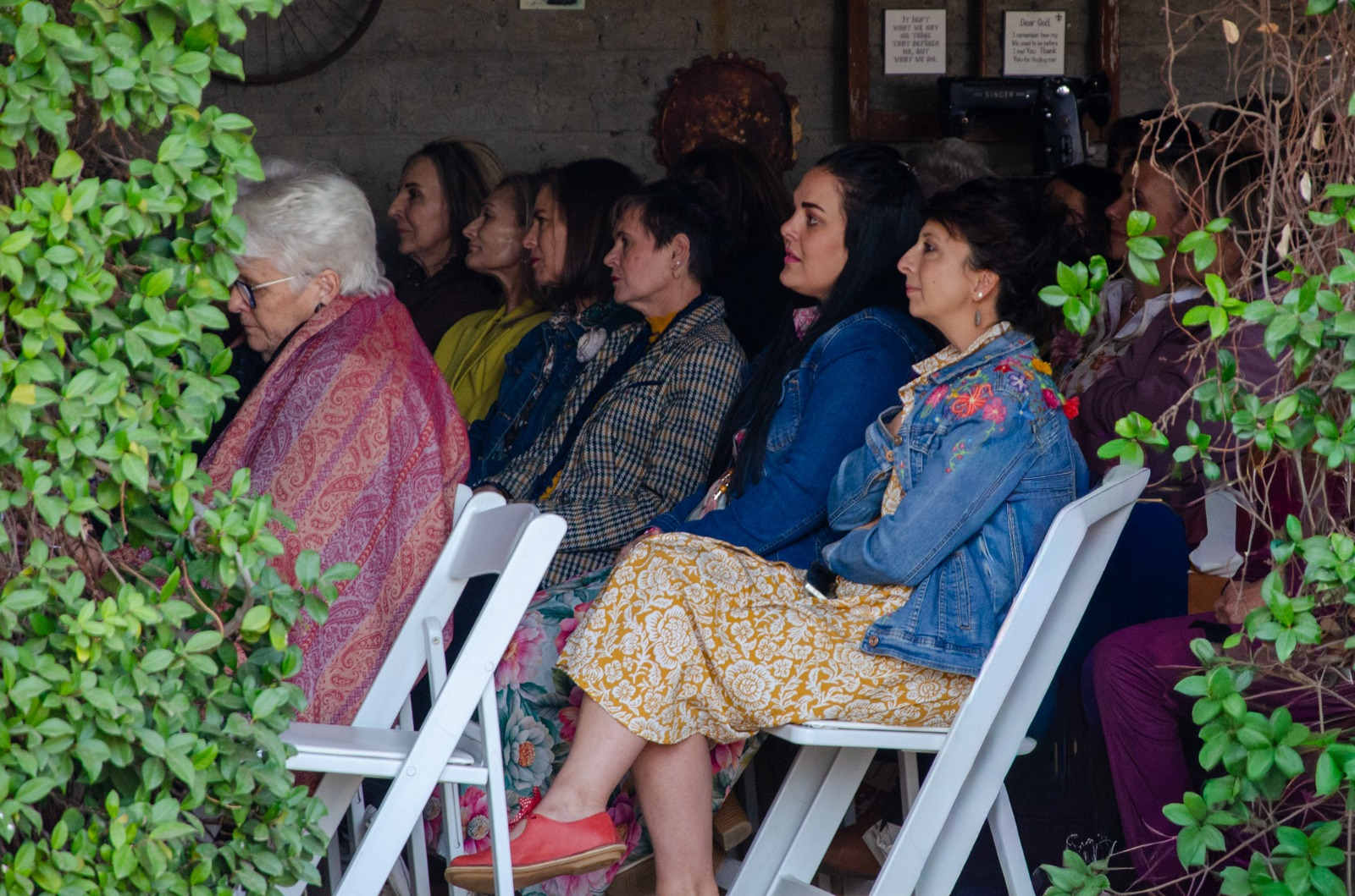Vroue sit in rye en luister aandagtig na ’n spreker by die Vrouedag-geleentheid.